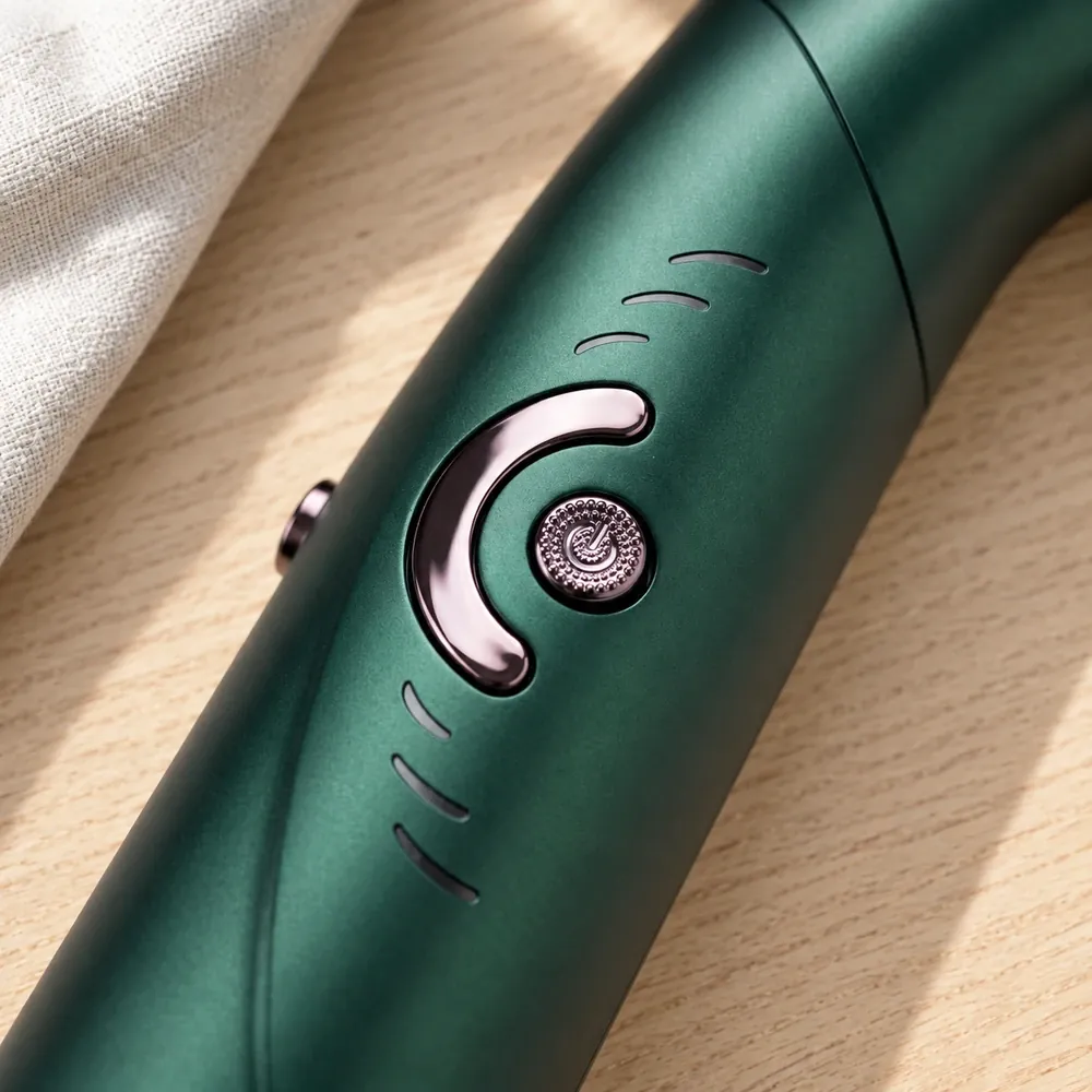 Close-up of the purple styling switch and cool-shot button on The Traveler's forest-green handle
